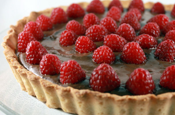 Crostata al cioccolato con lamponi - Ecco una crostata strepitosa e golosissima perfetta per un'occasione di festa, con un ricco ripieno cioccolatoso e uno strato di lamponi